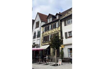 historisches Wohn- und Geschäftshaus in der Tauberbischofsheimer Fußgängerzone mit Parkplatz